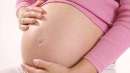 Schwangere Frau streichelt ihren Bauch