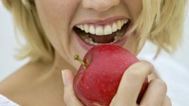 Frau beißt in einen Apfel