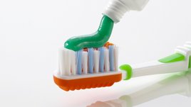 Grüne Zahnpasta auf bunter Hand-Zahnbürste