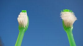 Neue Zahnbürste und gebrauchte Zahnbürste mit krummen Borsten
